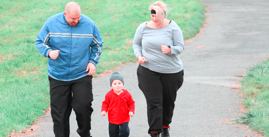 Overweight mom and dad jogging with mildly overweight son